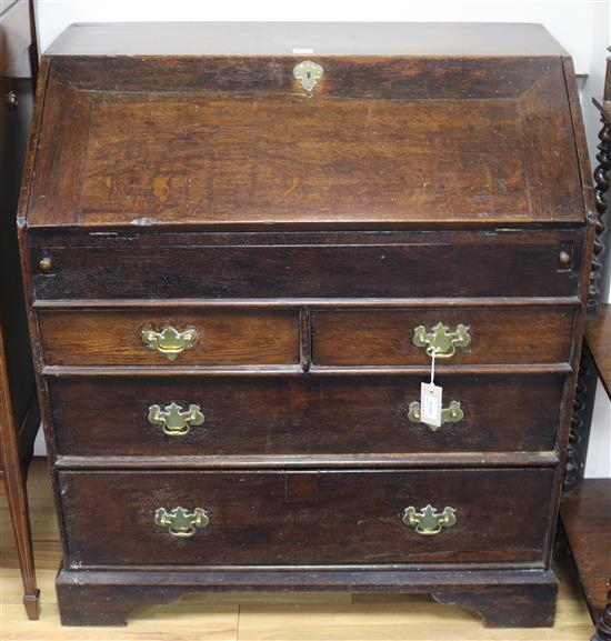 An early Georgian oak bureau, fitted fall front and five drawers, on bracket feet, W.87cm